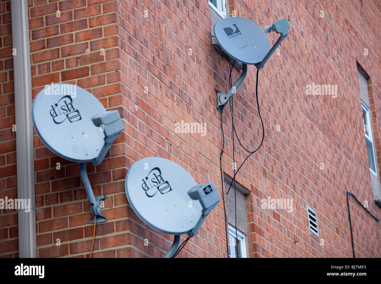 DirecTV and Dish Network satellite dishes on an apartment building.  Stock Photo