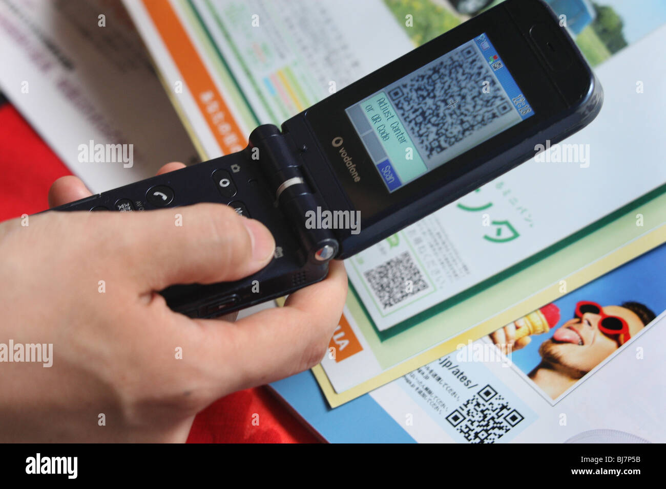 Using a mobile telephone to scan a 'QR Code' ( a square dot matrix barcode) to enable the telephone to download a weblink. Stock Photo