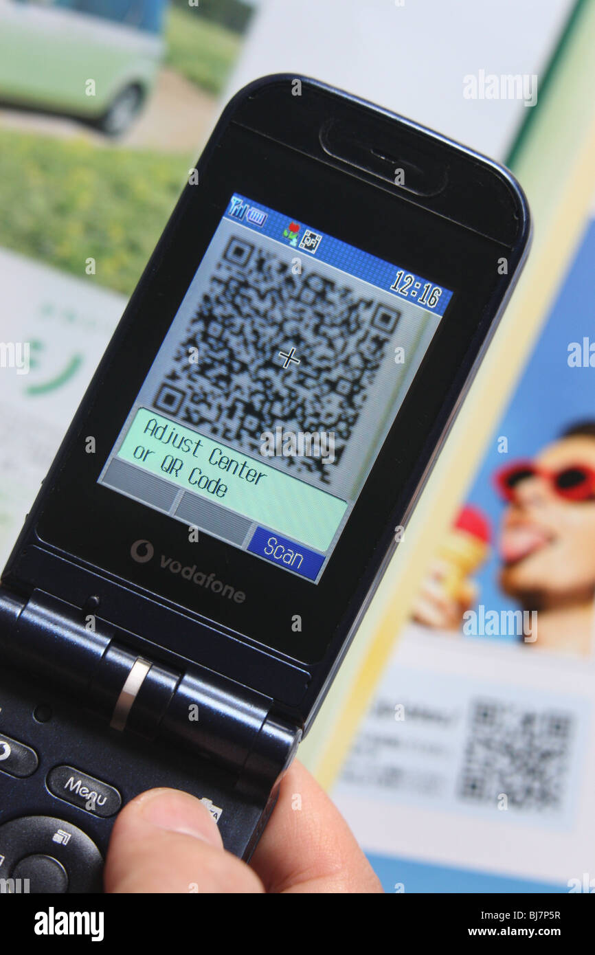 Using a mobile telephone to scan a 'QR Code' ( a square dot matrix barcode) to enable the telephone to download a weblink. Stock Photo