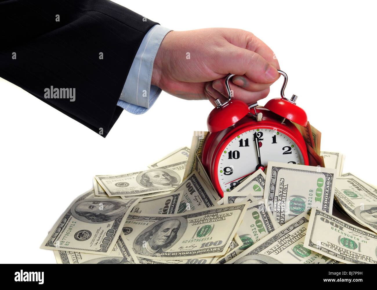 Male arm take out alarm clock from pile of money. Isolated for your. Deadline concept Stock Photo