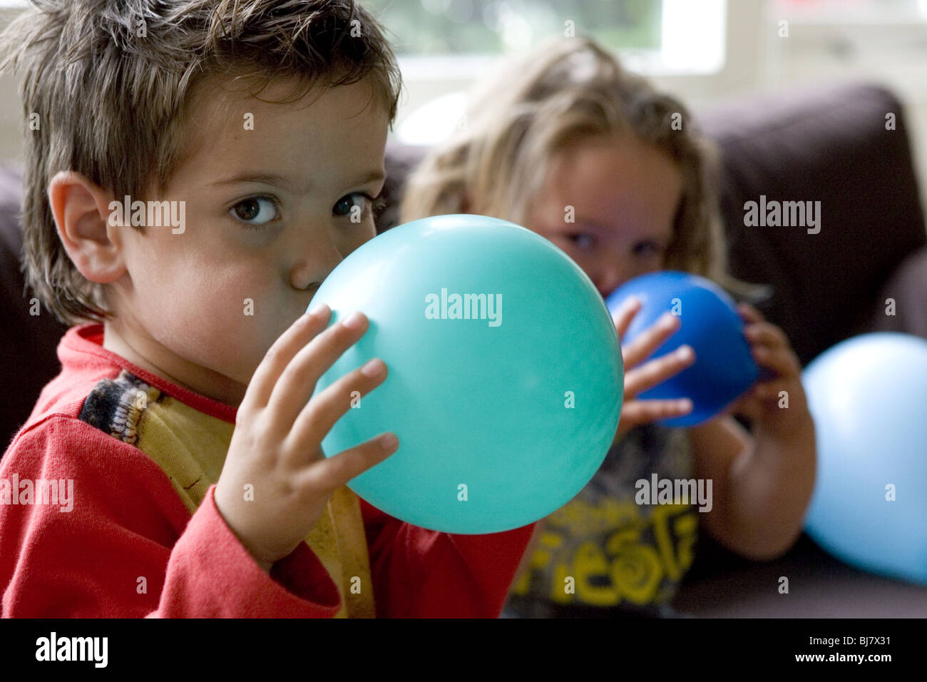 Children blowing balloons inside hi-res stock photography and images - Alamy