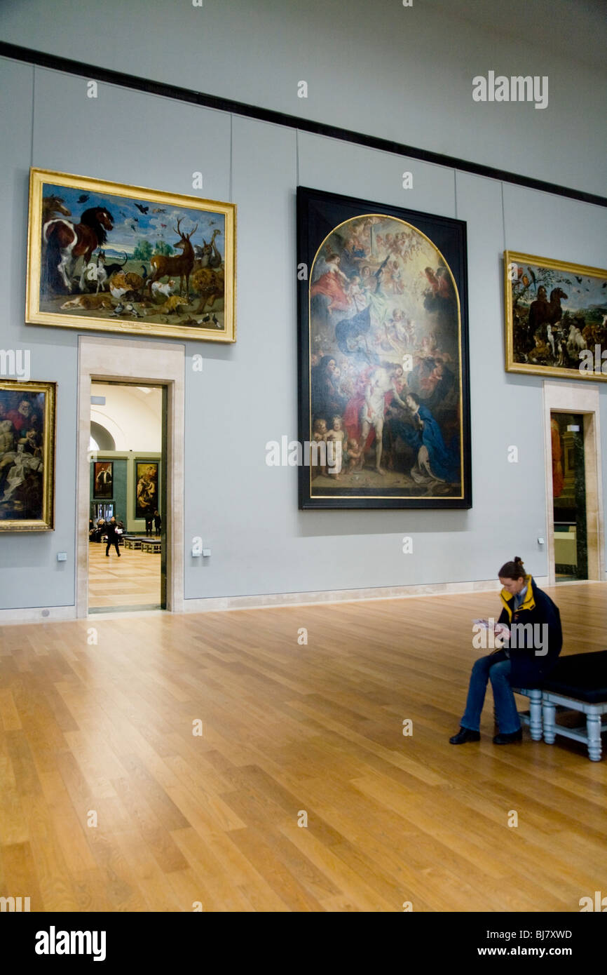 A tourist in gallery of old master type painting / paintings / masterpieces: The Palais du Louvre Museum / Musee. Paris, France Stock Photo