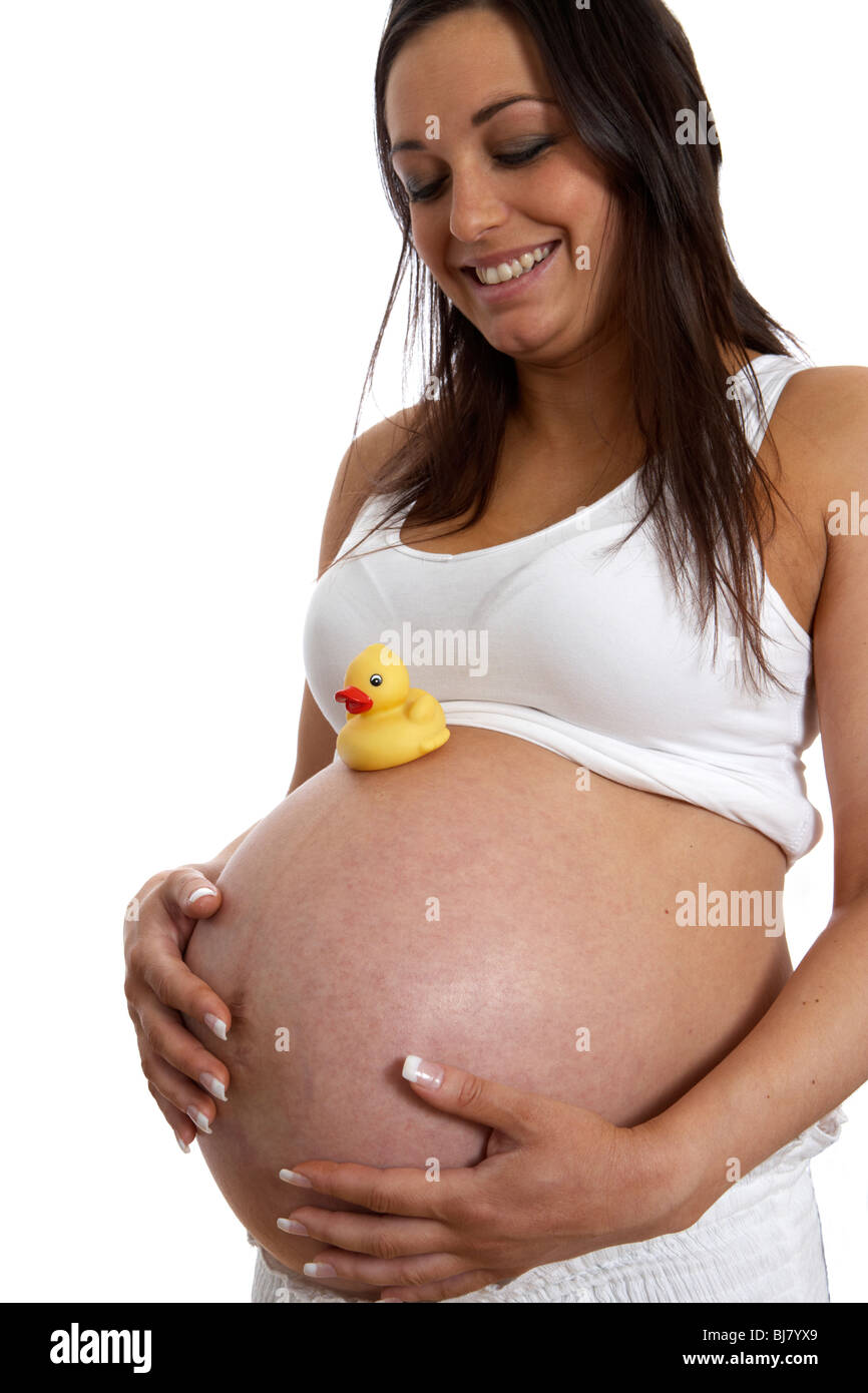 8 month pregnant woman 30 years of age with small yellow childs plastic duck on baby bump Stock Photo