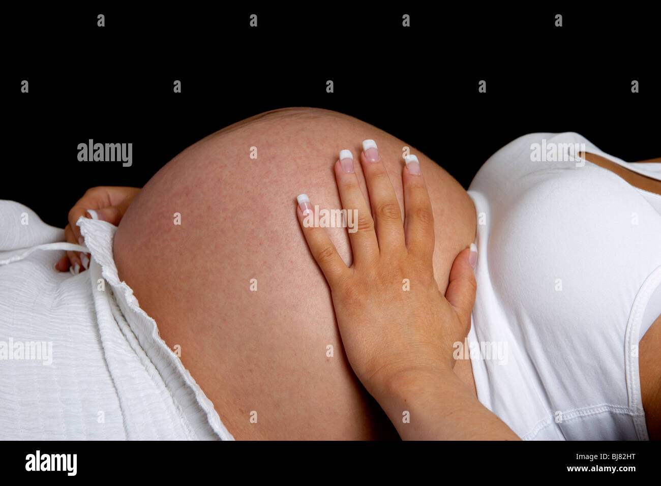 8 month pregnant woman 30 years of age with baby bump Stock Photo