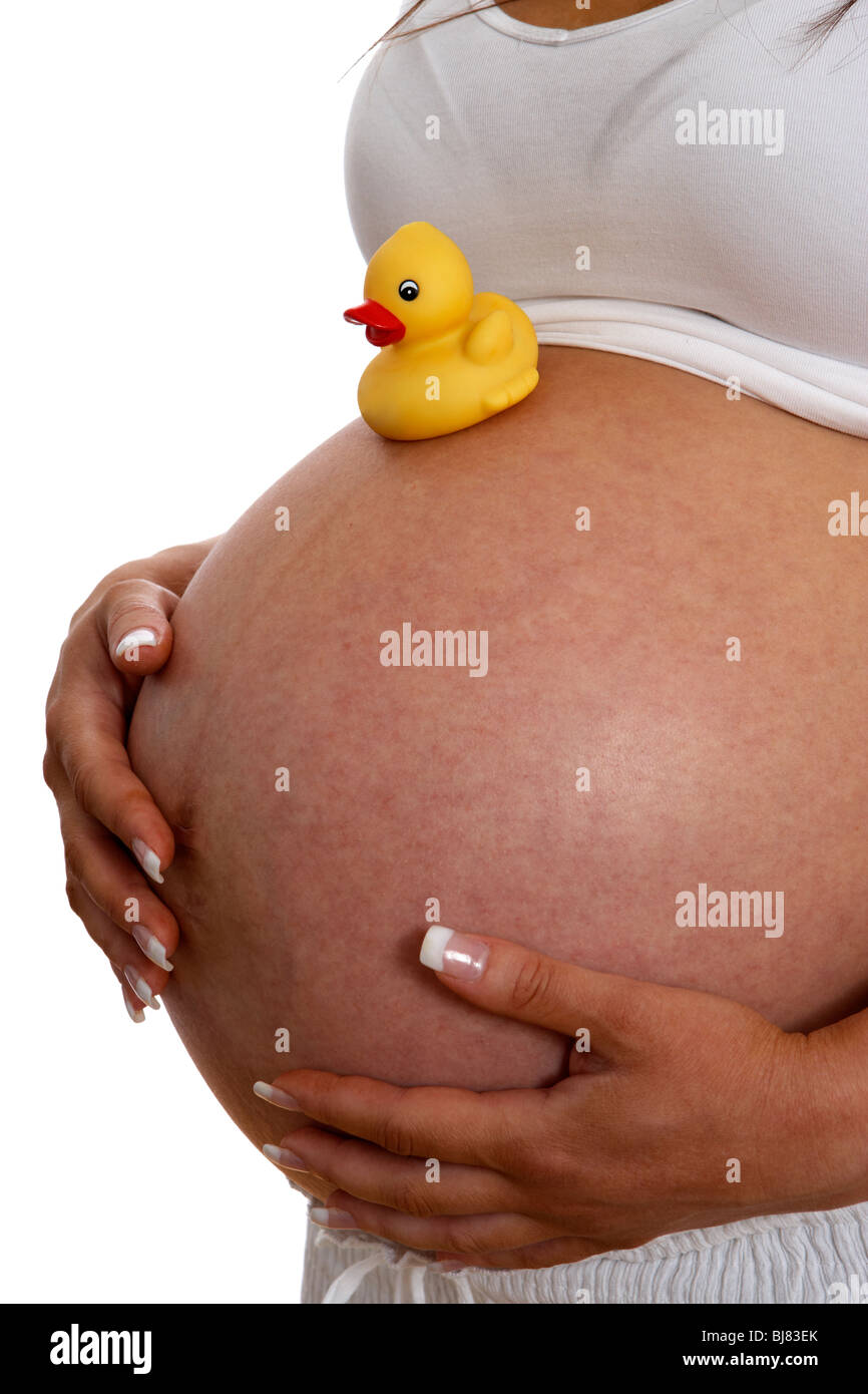 8 month pregnant woman 30 years of age with small yellow childs plastic duck on baby bump Stock Photo
