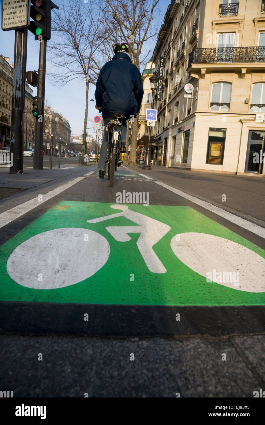Cyclist cycles along a French bicycle / bike / cycle / lanes / lane in