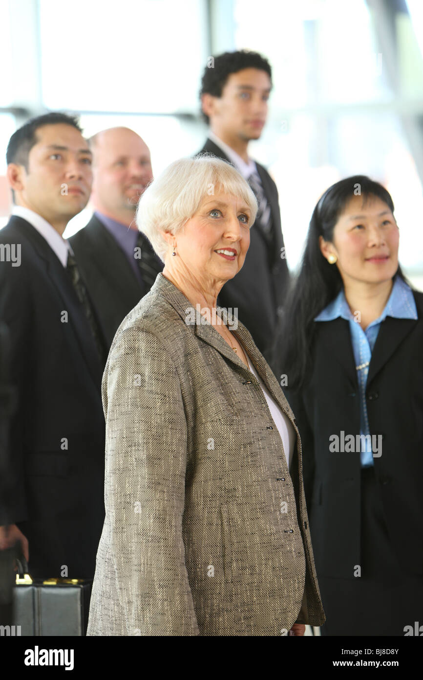 Group of businesspeople with senior businesswoman in foreground Stock Photo
