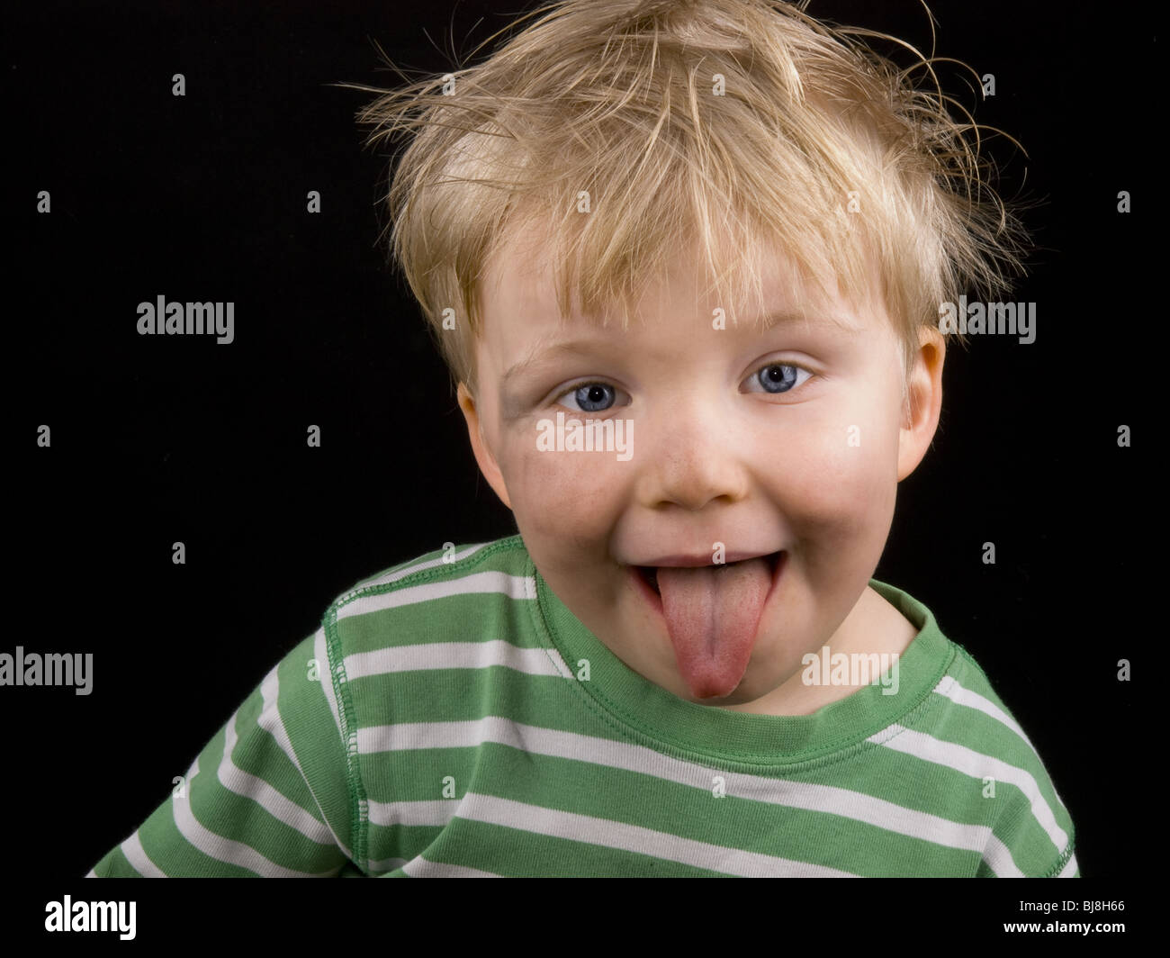 Little Boy Showing His Tongue On Black Background Boy Have Blue