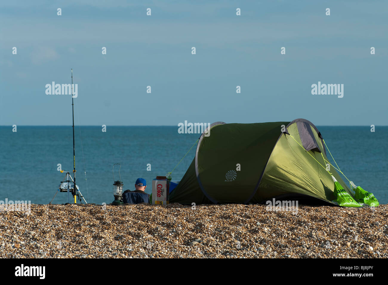 Sea angler waits to catch fish at Dungeness, Kent, England Stock Photo ...