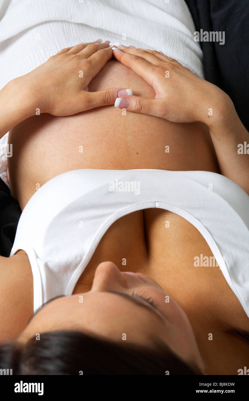 8 month pregnant woman 30 years of age with baby bump Stock Photo