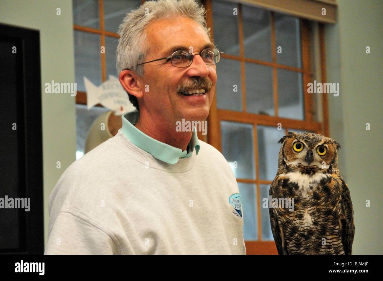 Great horned owl (Bubo virginianus) with naturalist Michael Brothers at the Marince Science Center in Ponce Inlet, Florida Stock Photo