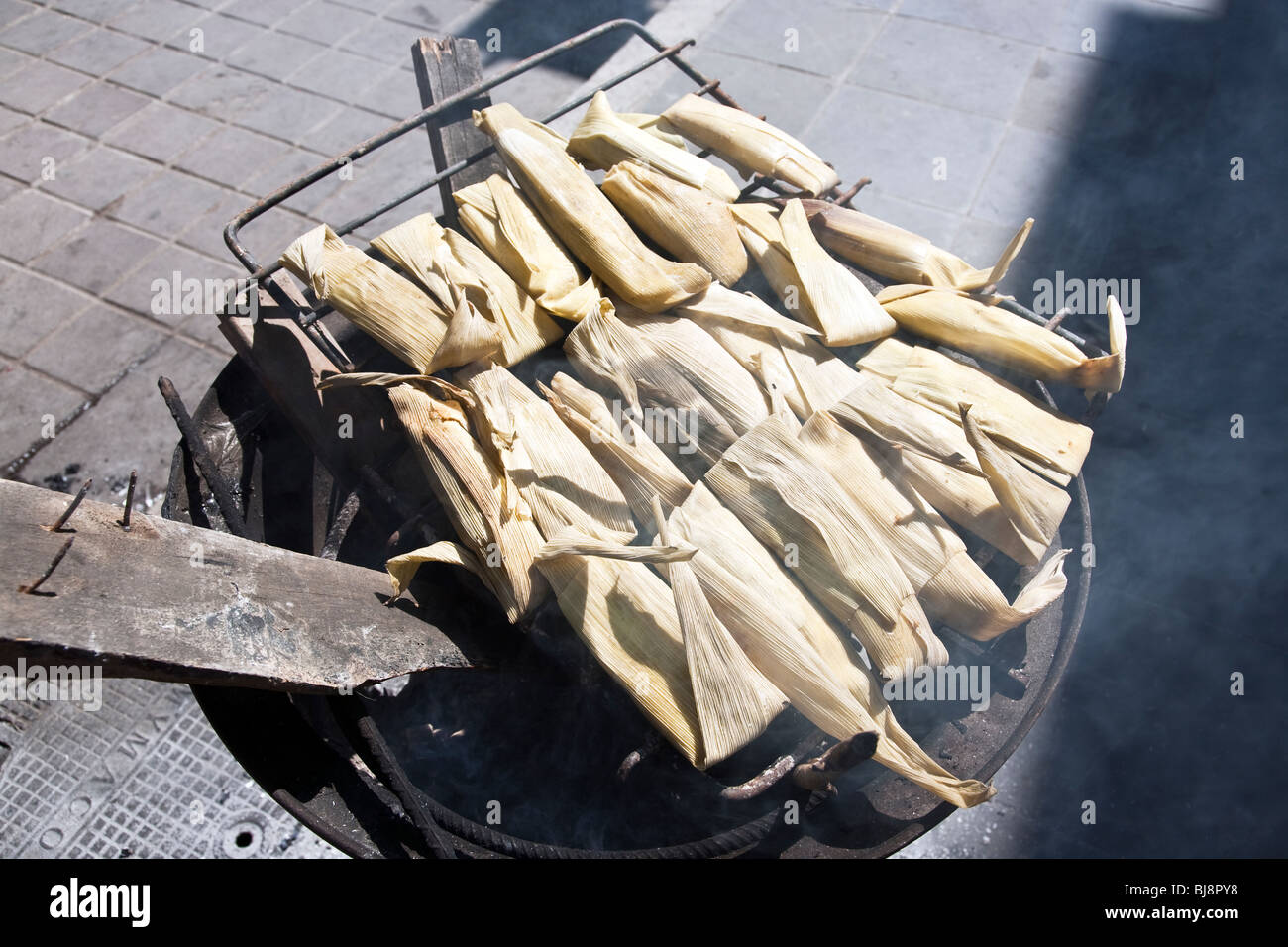 tamales to nourish Mixtec Indians protesting for indigenous rights cooking outside on a charcoal stove In Oaxaca City Zocalo Stock Photo