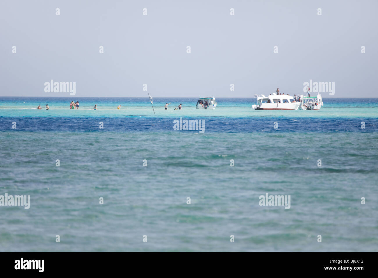 People walking and snorkeling in shallow water Stock Photo