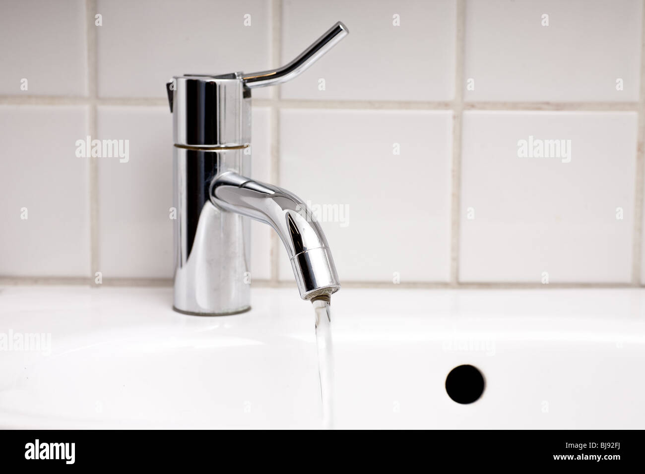 close up of sink and tap with running water in bathroom Stock Photo - Alamy