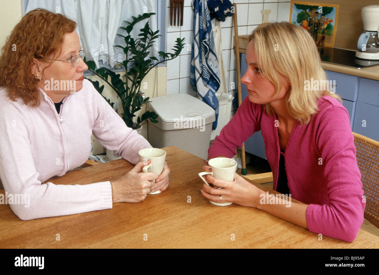 Mother and her adult child still living at home have a serious talk at home at the table.  SerieCVS500202167 Stock Photo