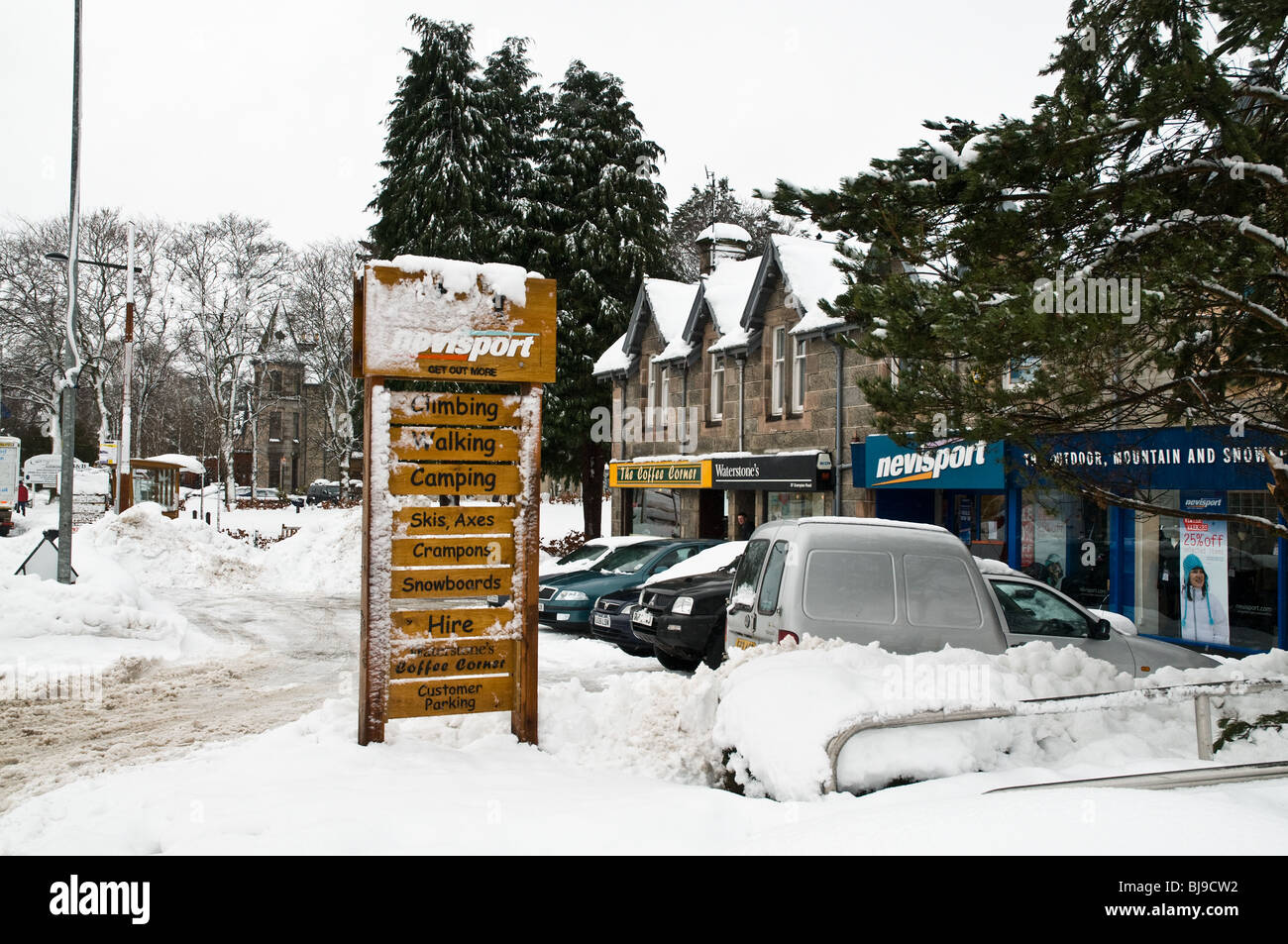 dh  AVIEMORE INVERNESSSHIRE Winter sports snow covered shop sign post and shops Stock Photo