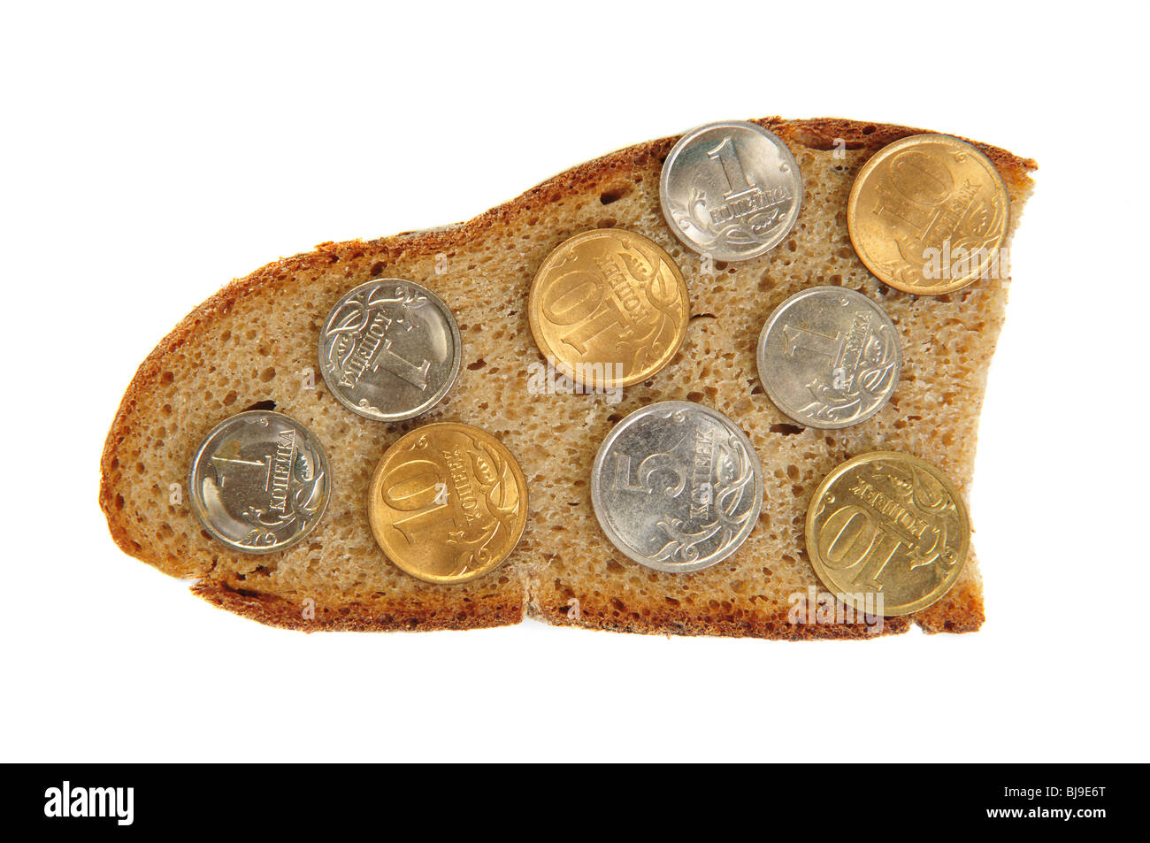 Coins on rye bread slice. Isolated over white Stock Photo