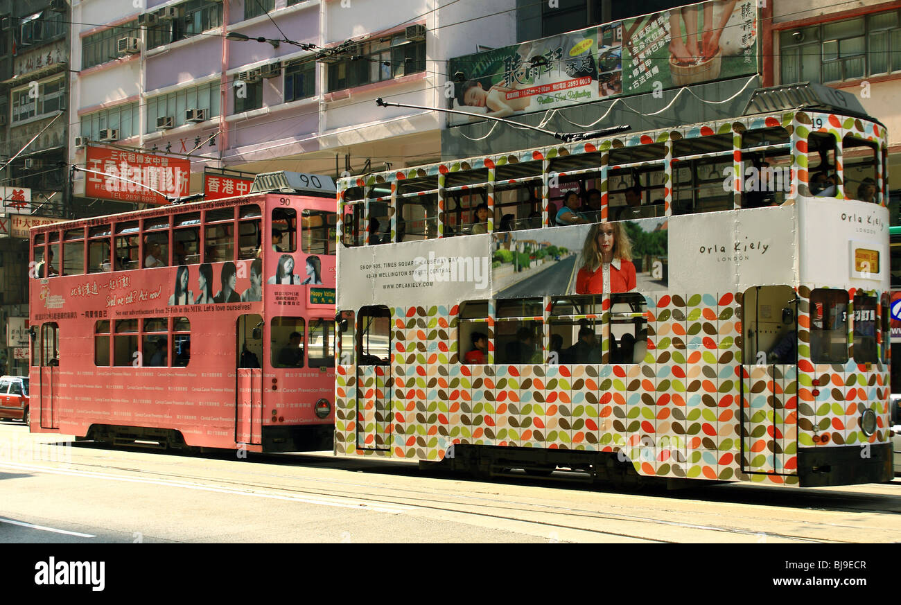 Two double decker electric trams with trendy decorations in Hong Kong Downtown , China. Stock Photo