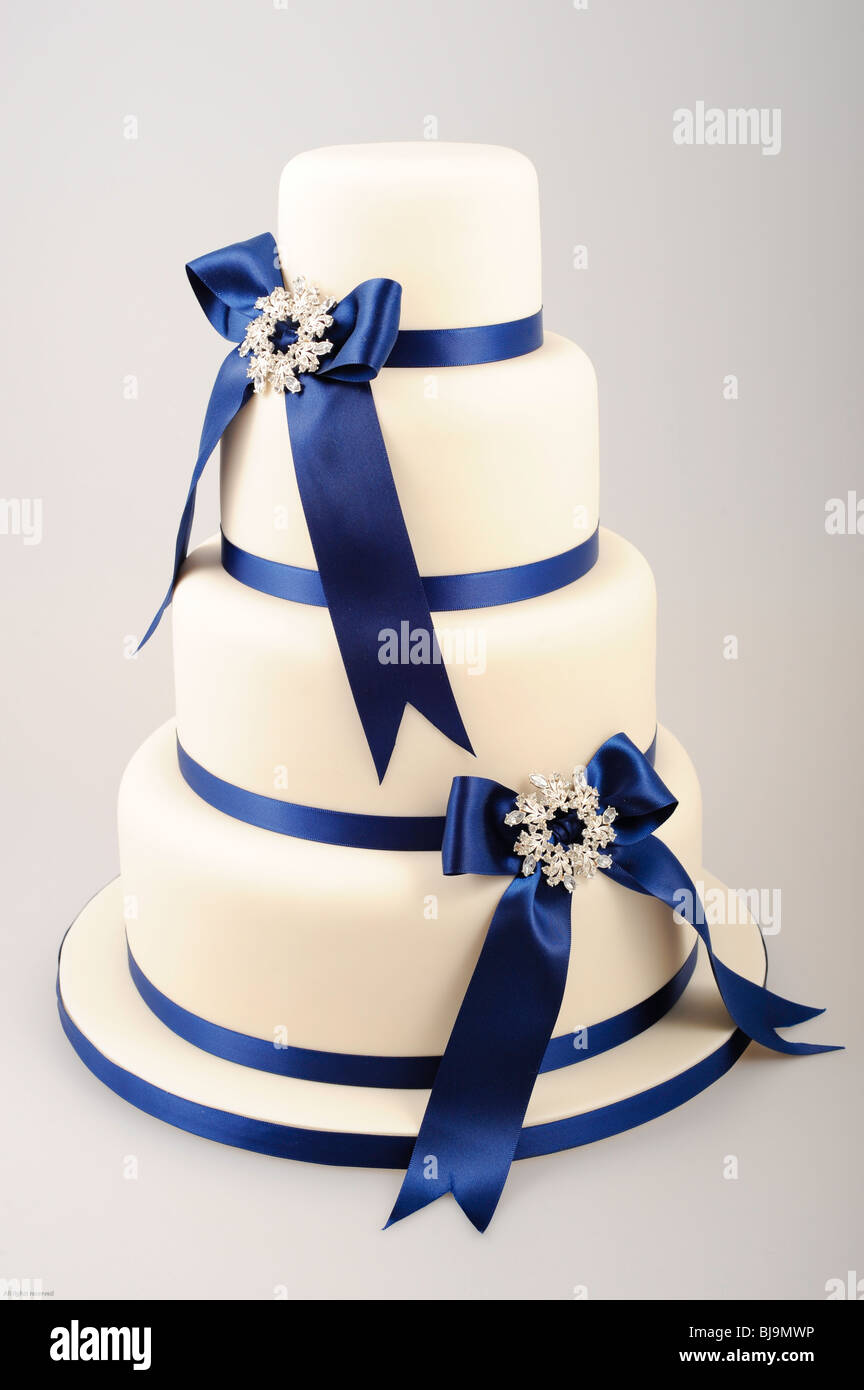 Four tiered cake with royal blue ribbons in bows with diamond center Stock Photo