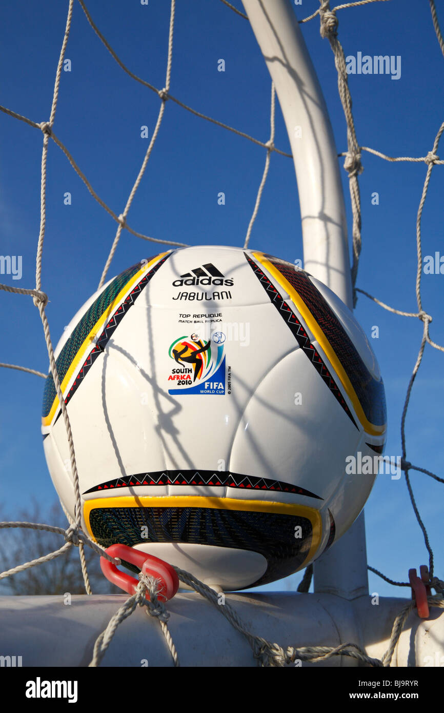 The FIFA 2010 World Cup match ball by Adidas, the Jabulani, in the corner of a football net. Stock Photo