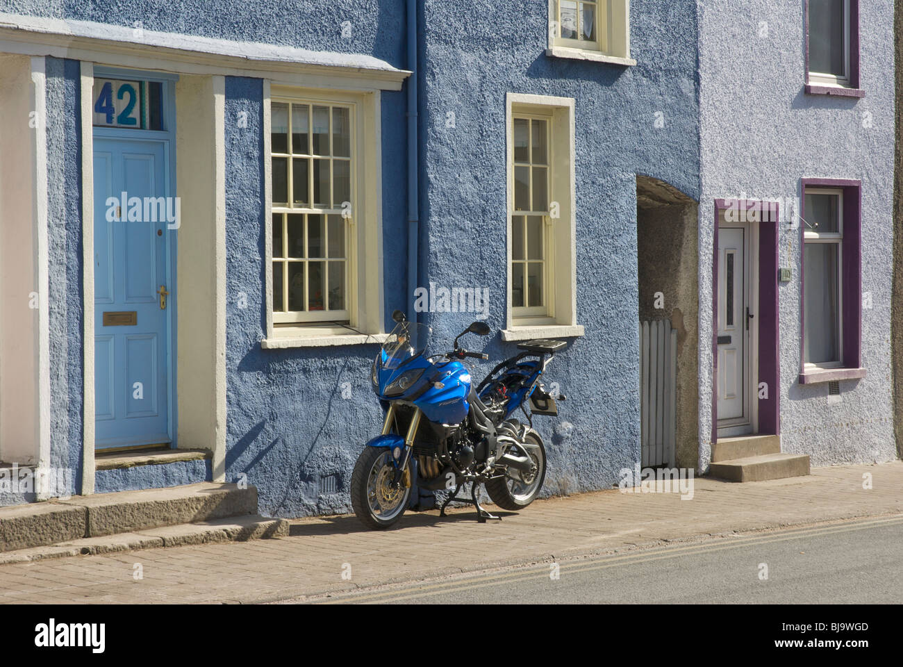 Motorbike parked (and getting its battery charged) on Soutergate, Ulverston, Cumbria, England UK Stock Photo