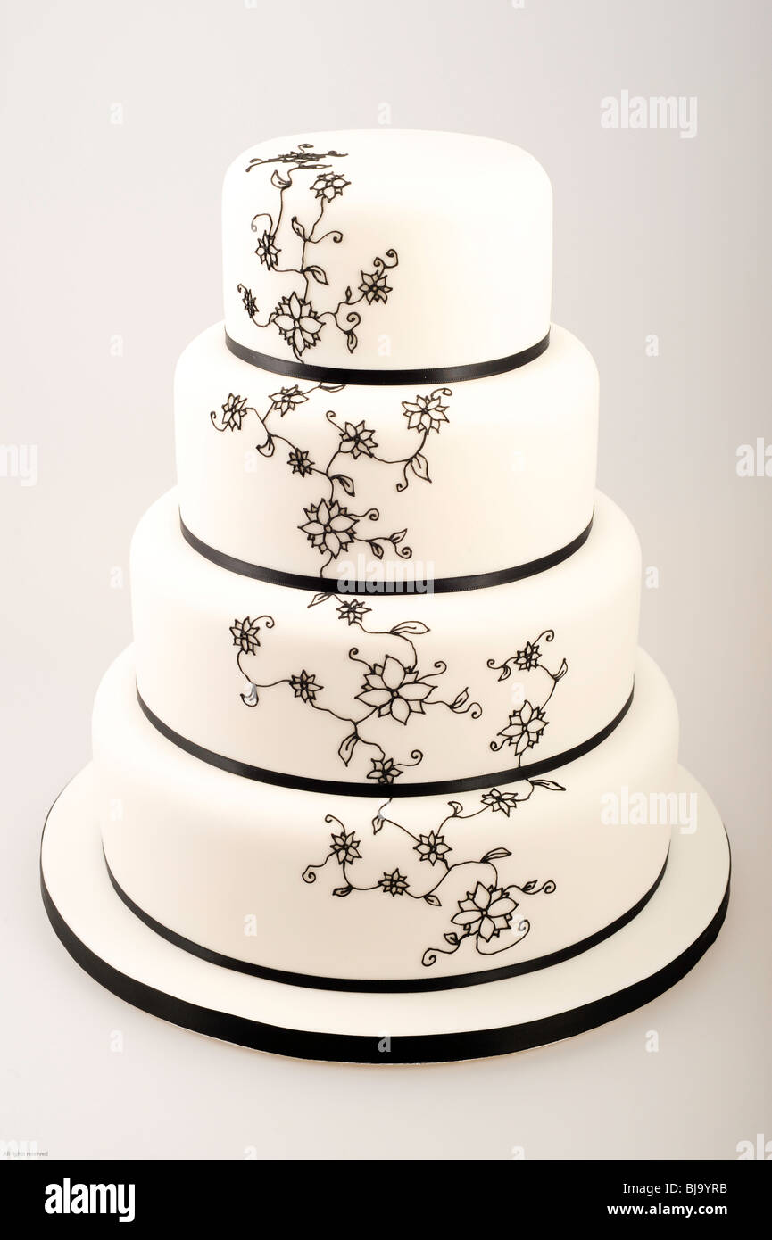 Elegant four tiered cake with black ribbon and intricate black flower shaped sugar pipe work / frosting Stock Photo