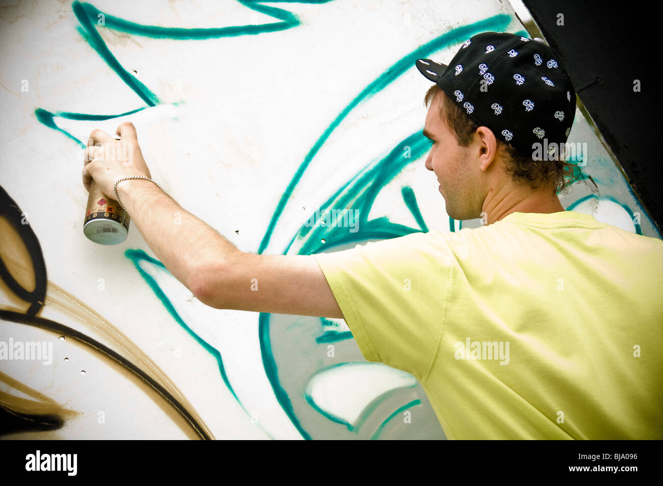 Young caucasian male graffiti artist with can of aerosol paint in hand ...