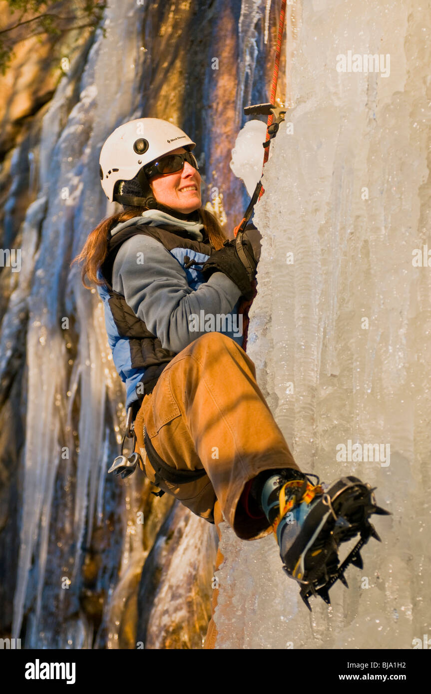 Woman ice climbing with crampons and ice tools on vertical ice in the New River Gorge, WV. Stock Photo