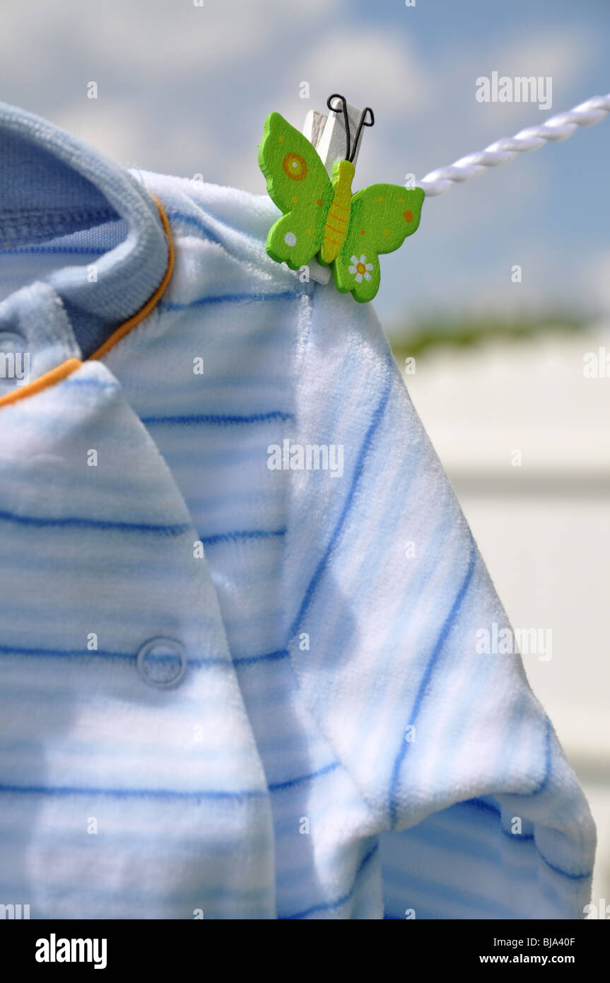 Small blue baby sweater hanging outside in the sunshine Stock Photo