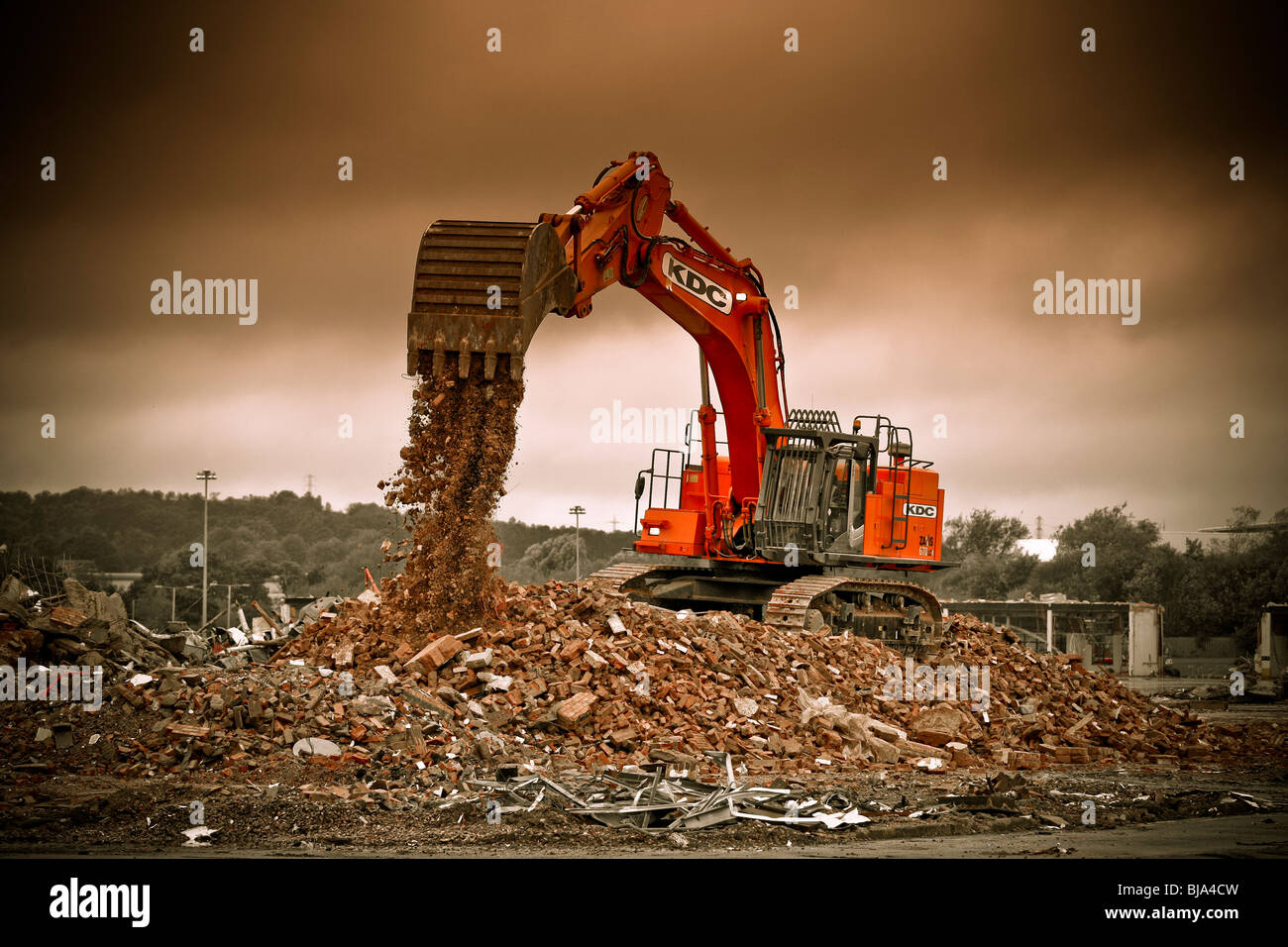 A digger working on the demolition of industrial an site. Stock Photo