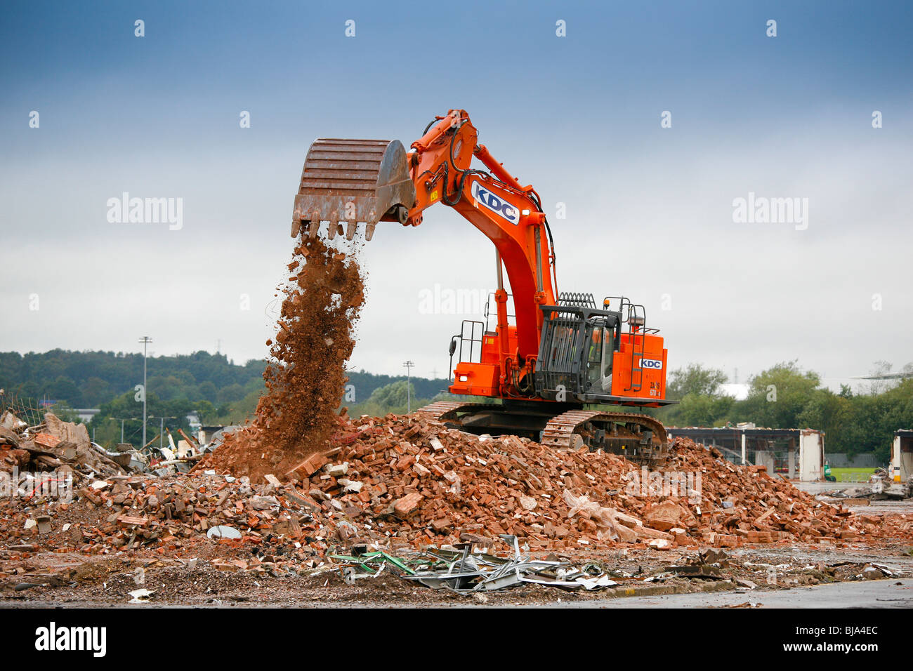 A digger working on the demolition of industrial an site. Stock Photo