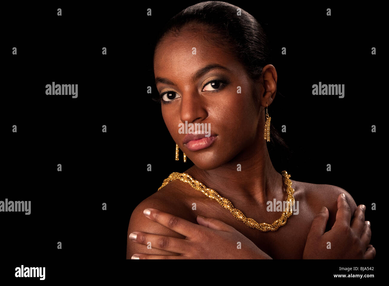Face of beautiful African American woman with gold earrings and necklace, isolated. Stock Photo