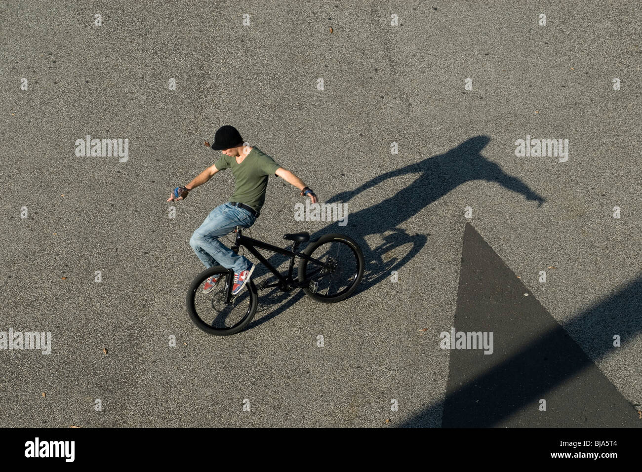 A teenager sitting on handle bars of a bike, Basel, Switzerland Stock Photo