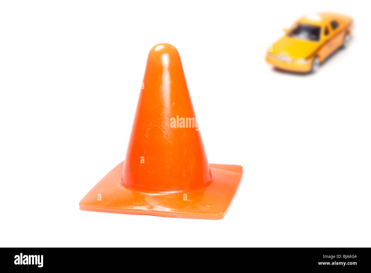 Safety cone with cab approaching in distance Stock Photo