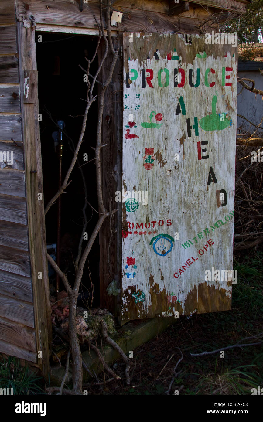 An abandoned shack in rural North Carolina. The door is a sign form a roadside produce stand. Stock Photo