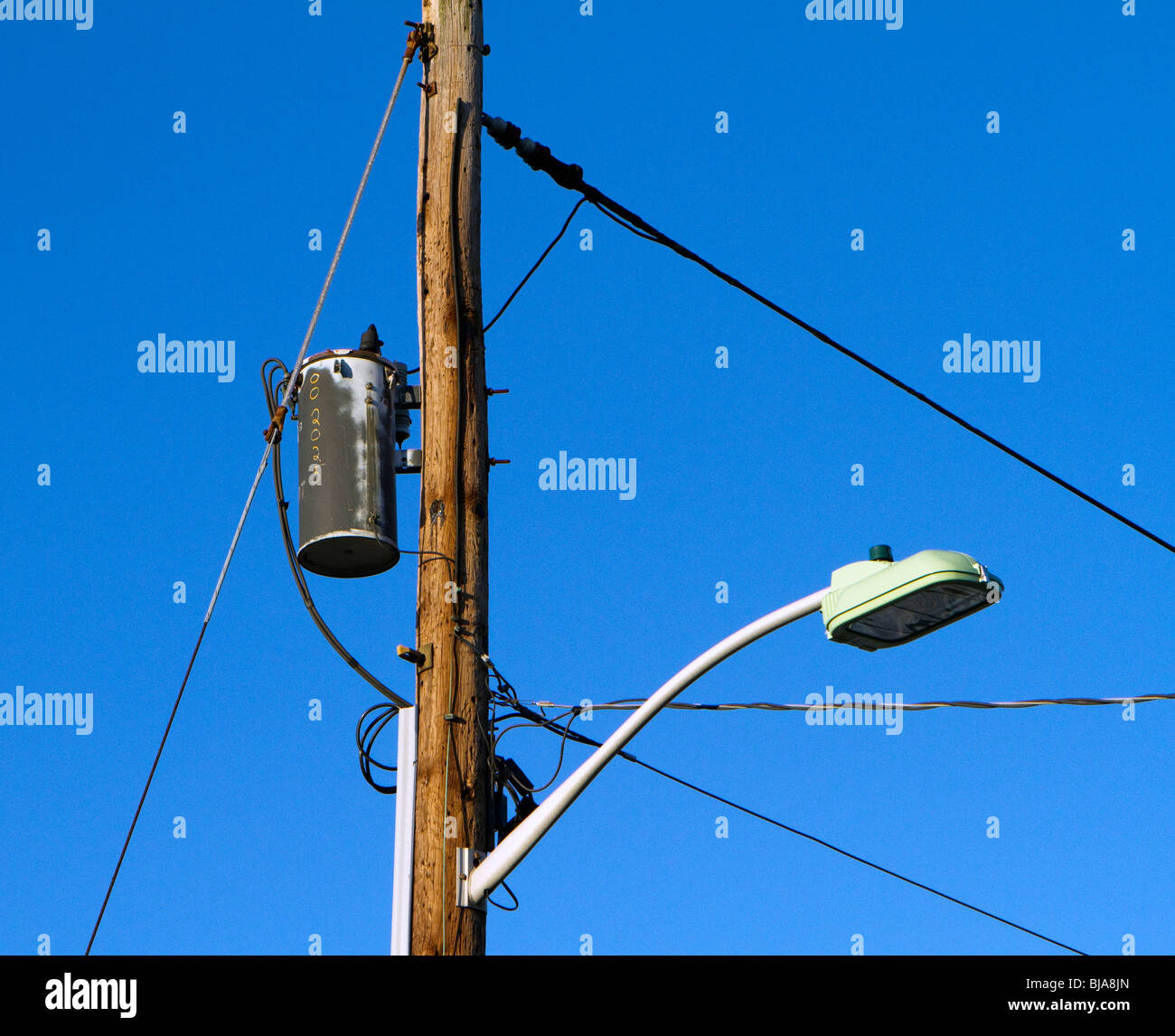 Utility pole with street lamp, wires and transformer. Stock Photo
