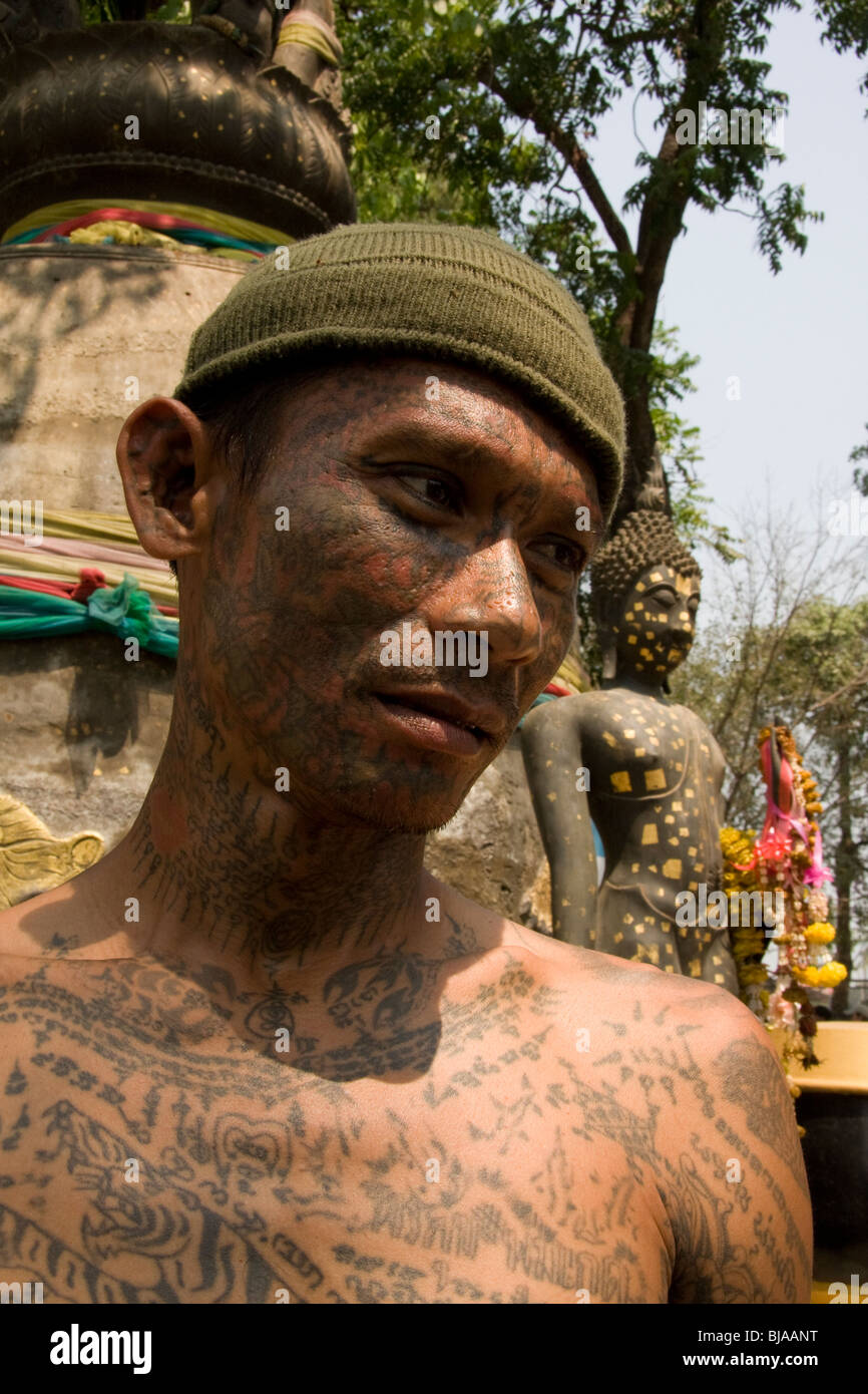 A young man´s sacred facial tattoos at Wat Bang Phra temple in Thailand, where monks tattoo devotees with protective prayers. Stock Photo