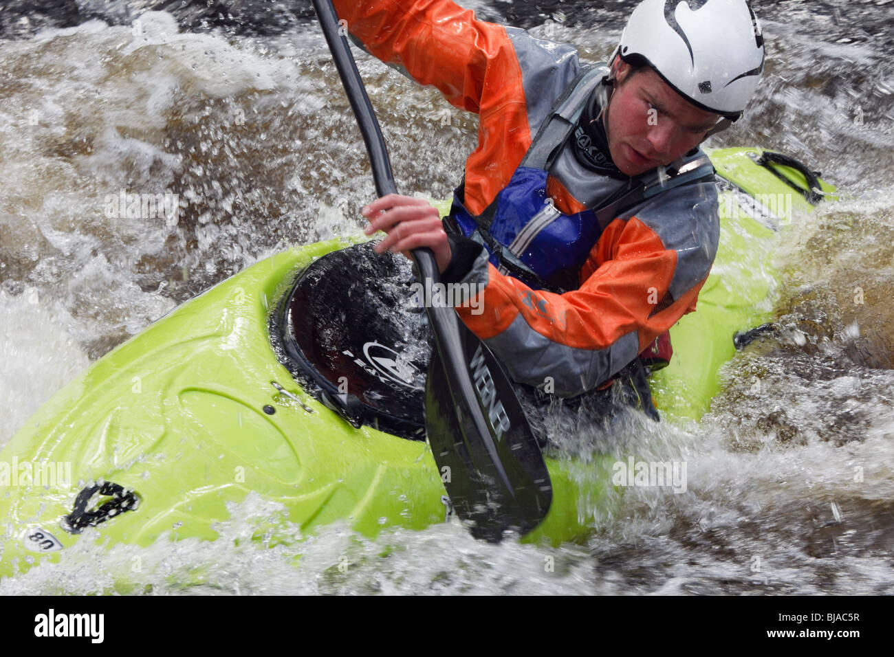Kayaker kayaking in a kayak canoe in white water on Tryweryn River at