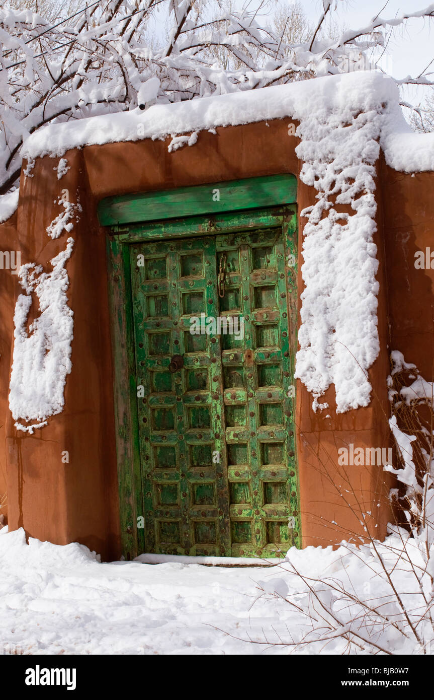 Ornate wooden doorway in adobe wall in Santa Fe New Mexico Stock Photo