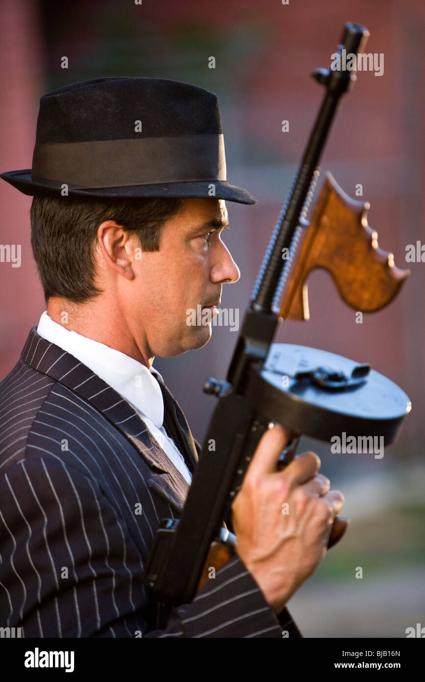 Profile of gangster holding Tommy gun Stock Photo - Alamy