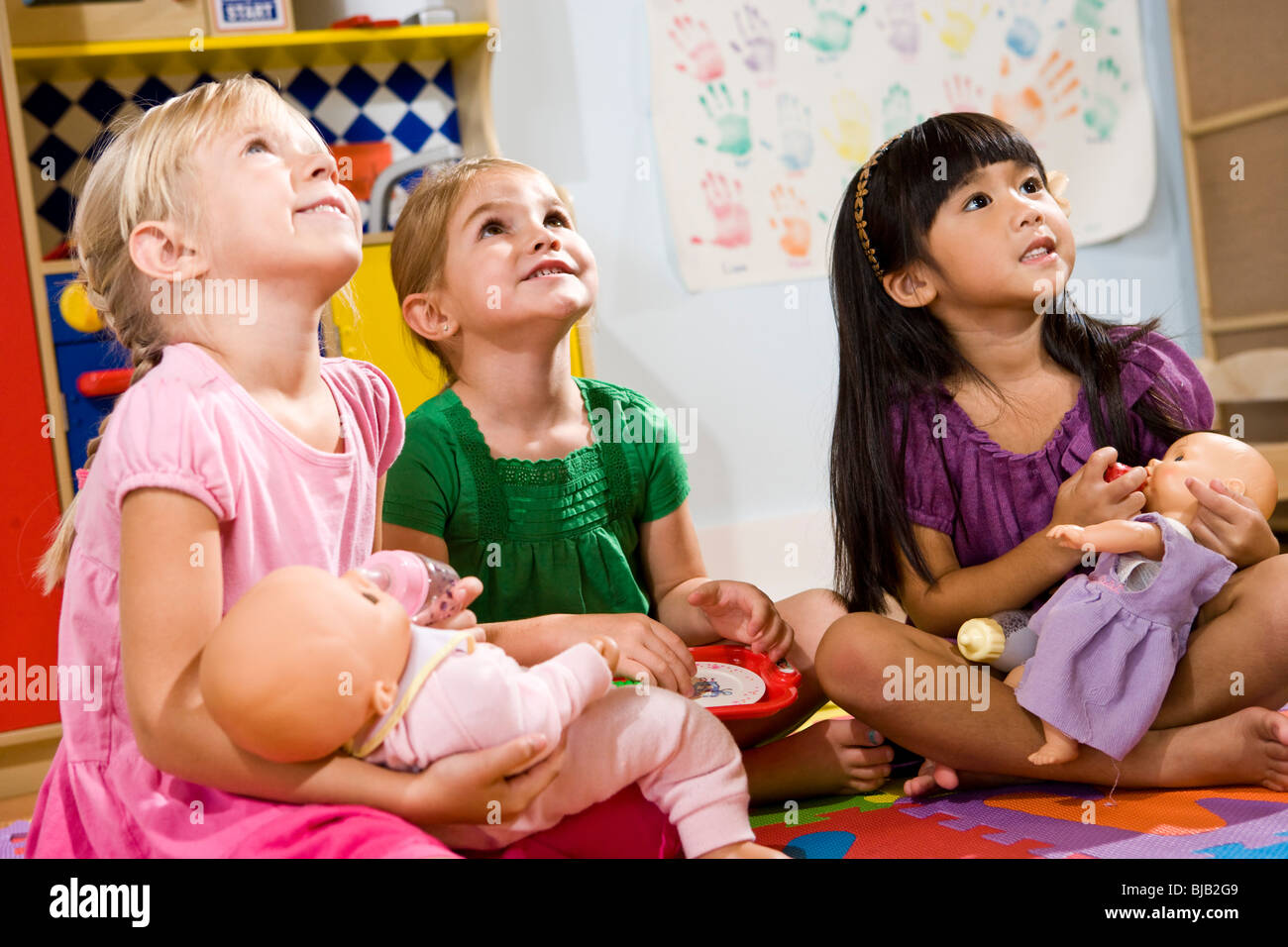 Little preschool girls playing with dolls Stock Photo