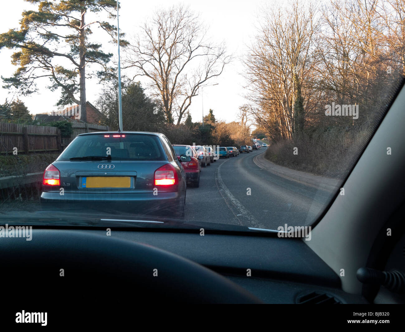 Traffic jam viewed from driving seat of car on a suburban road in the UK Stock Photo