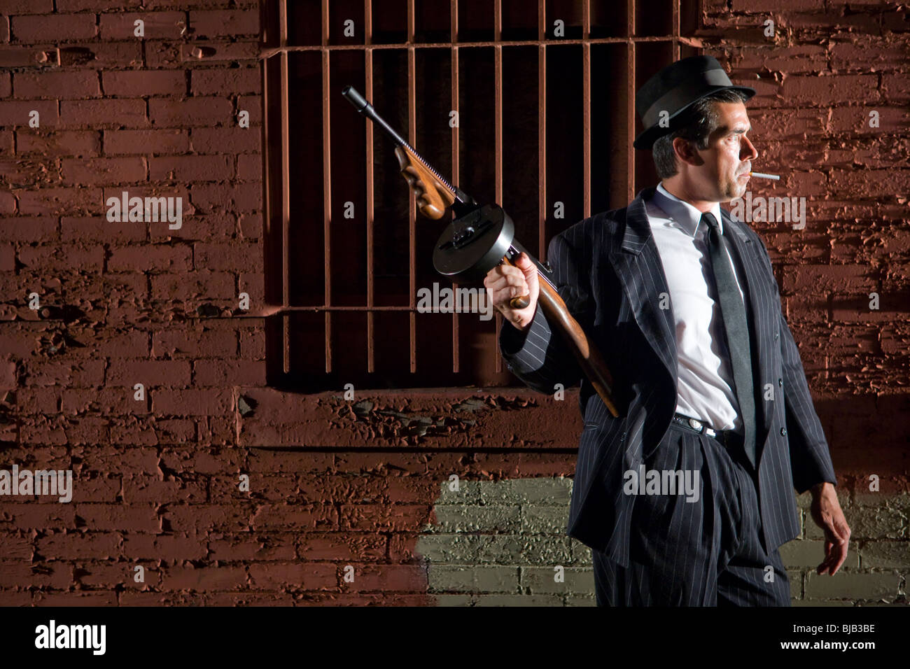 Gangster in dark pinstripe suit with Tommy gun Stock Photo Alamy
