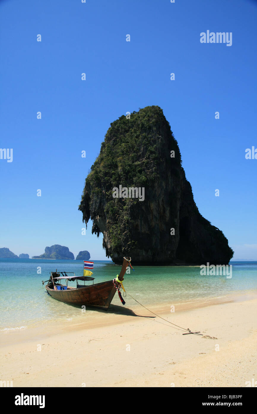 traditional wooden long tail boat on tropical Phra Nang beach by happy Island, Thailand Stock Photo
