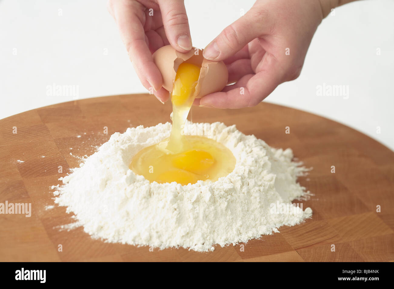 breaking egg into pasta ingredients Stock Photo