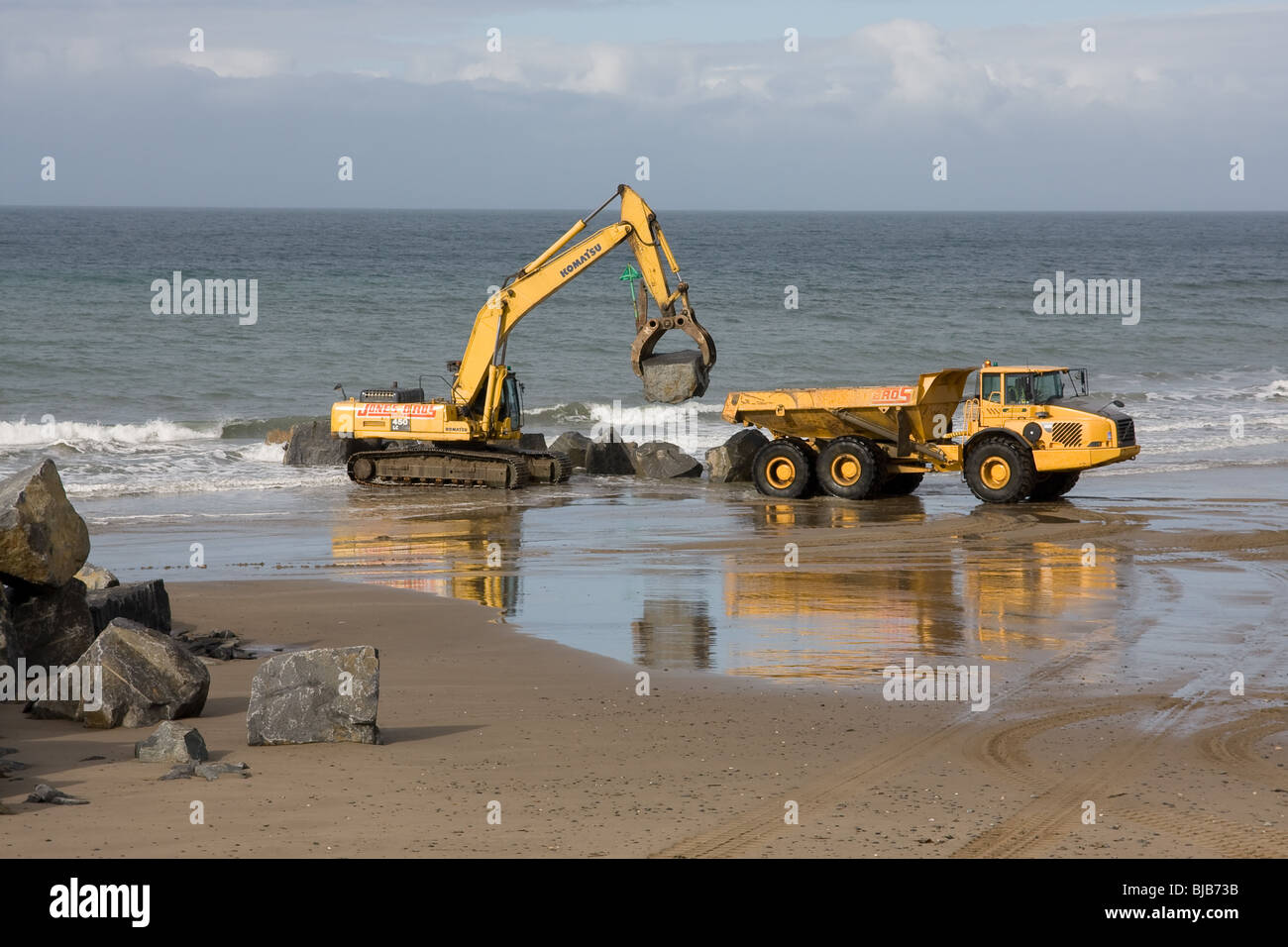 Moving boulders on the beach, tywyn Stock Photo
