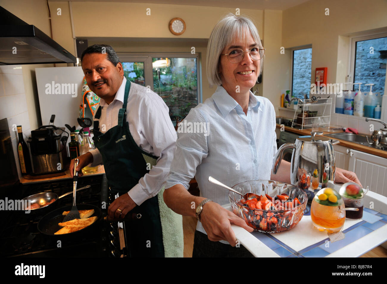 A couple running a bed and breakfast guesthouse prepare breakfast for their guests UK Stock Photo