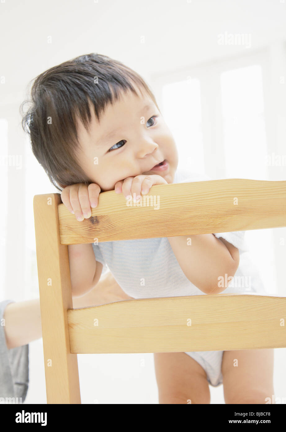 Baby leaning over on chair Stock Photo Alamy