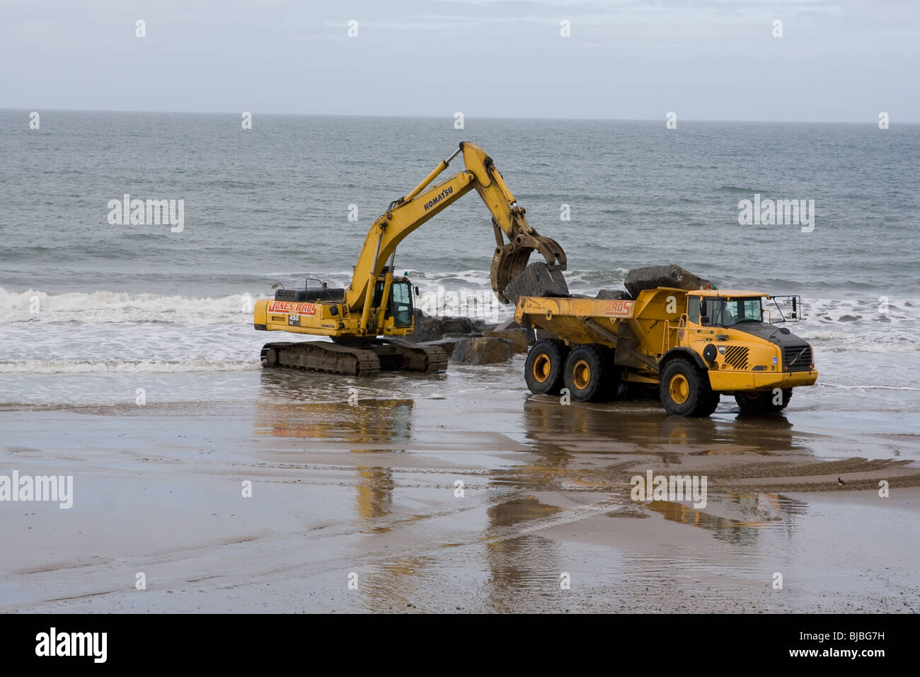 Moving boulders on the beach, tywyn Stock Photo