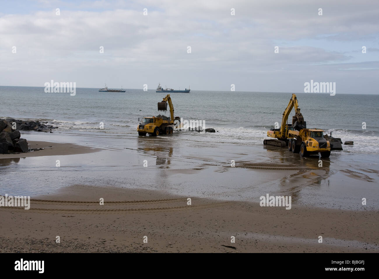 Moving boulders on the beach, tywyn Stock Photo